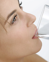 Frau trinkt aus einem Glas Wasser